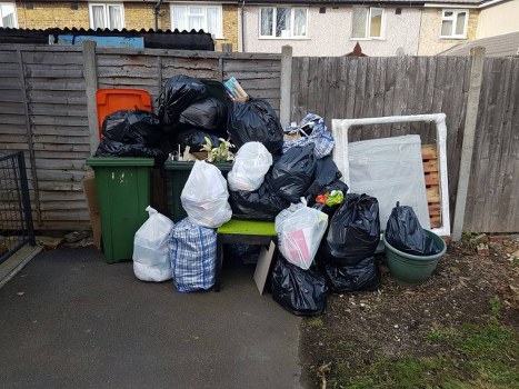 Professional waste removal crew loading items from a city flat